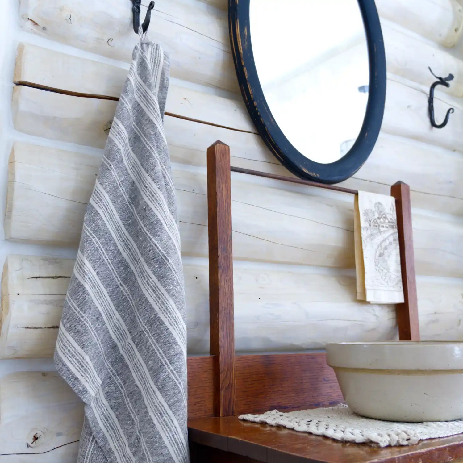 flax linen hand towel hanging from metal hook in log house