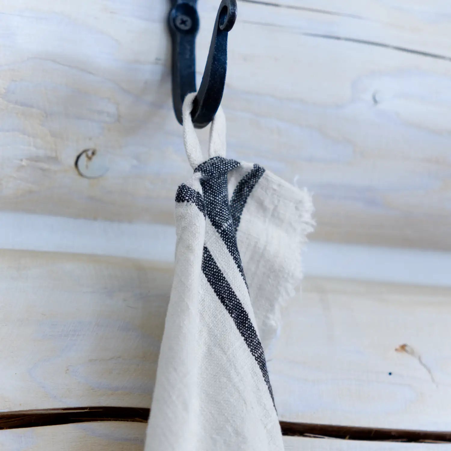antique white flax linen hand towel hanging from hook.