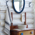 white and black stripe flax linen hand towel hanging from metal hook in log house