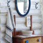 white and black stripe flax linen hand towel hanging from metal hook in log house