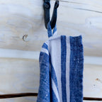 Blue and white stripe flax linen hand towel hanging from hook.