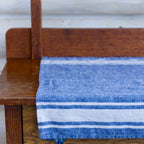 white and blue stripe flax linen hand towel laying flat on wood cabinet